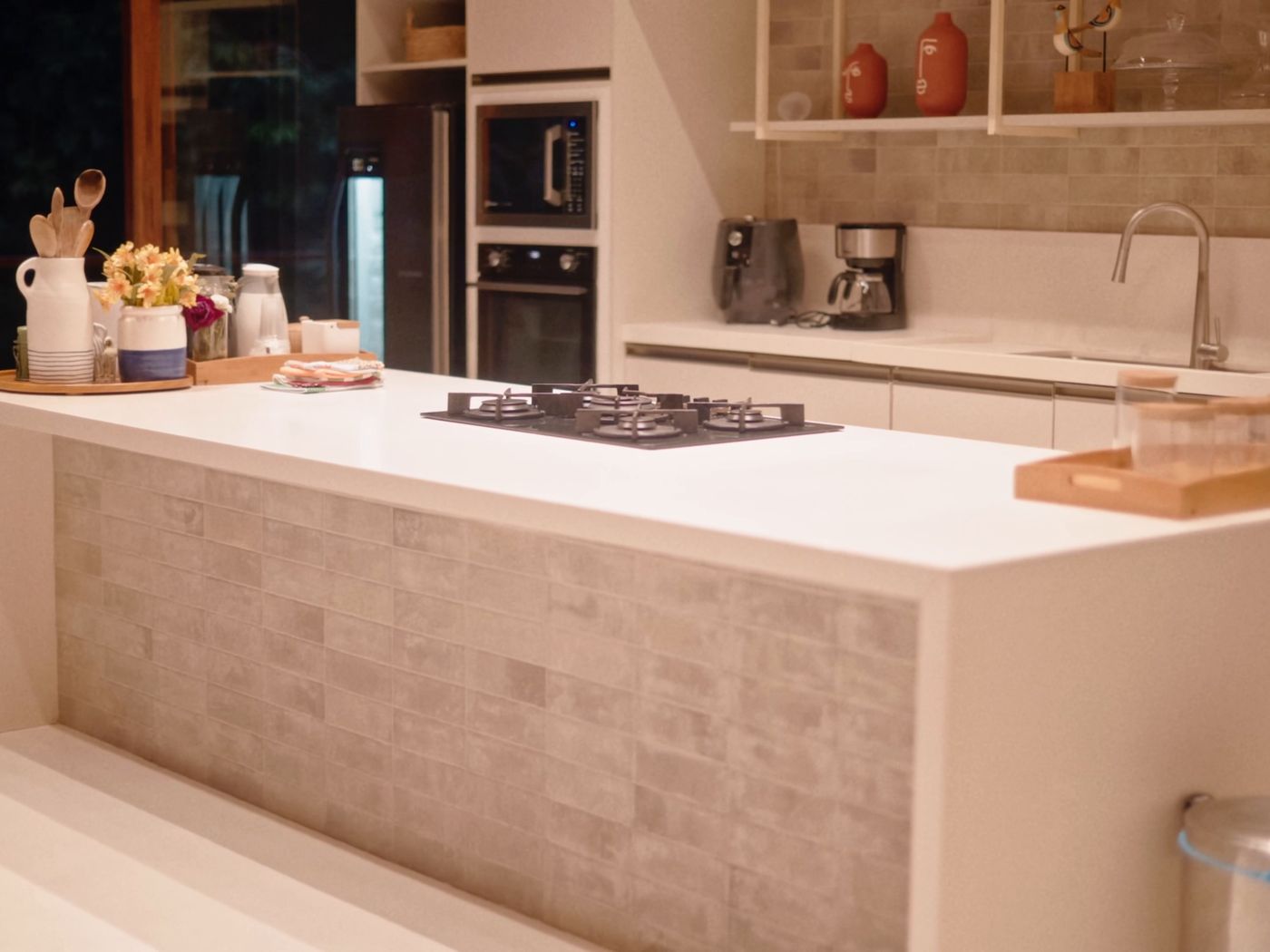 Cocina moderna con isla blanca y revestimiento de piedra